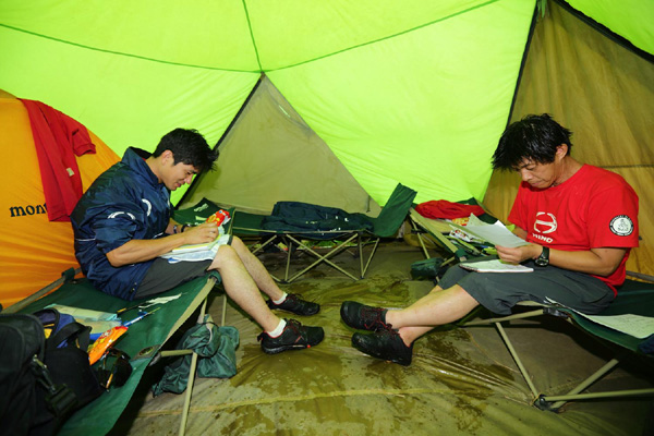 テントでロードブックの予習をする羽村勝美と杉浦博之