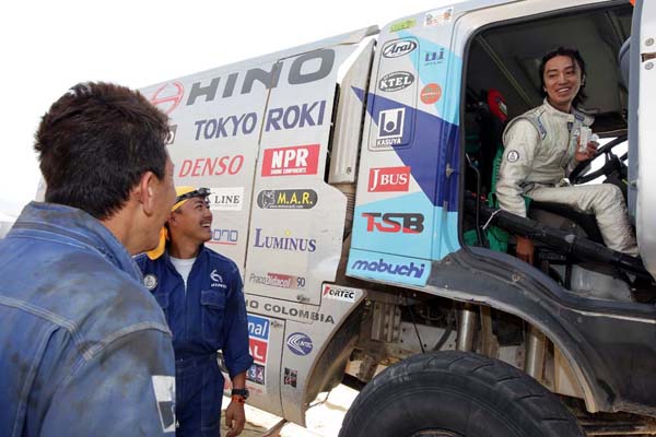 Mechanics waiting as Car 2 reaches its goal.