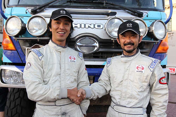 Teruhito Sugawara and Seiichi Suzuki firmly shaking hands after safely reaching the goal.