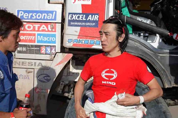 ビバークに到着し、末次健一メカニックに状況を伝える菅原照仁