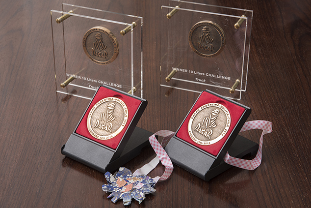 お孫さん手づくりのメダル（中央）とクラス優勝の楯（奥）と完走メダル（手前）