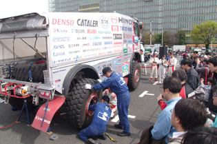 タイヤ交換のデモンストレーションを行うメカニック